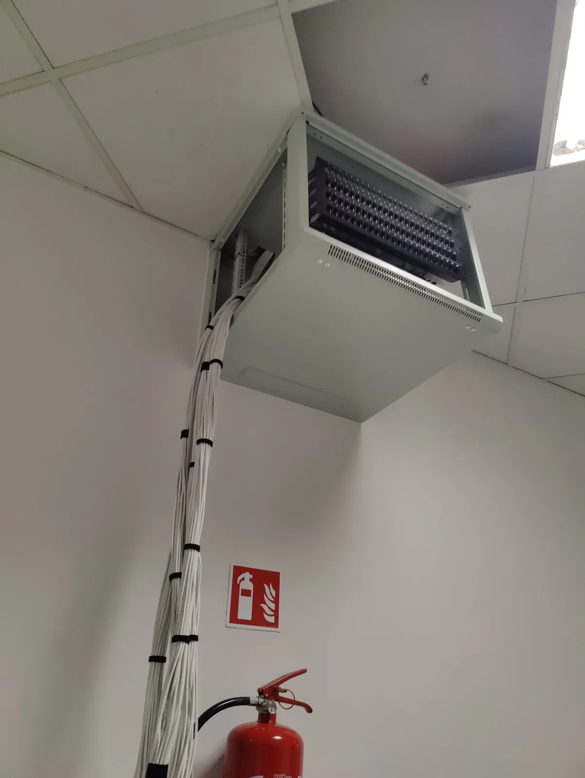 Uporządkowane wiązki przewodów prowadzone do szafy rack w trakcie prac
